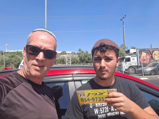 תלמיד מחזיק את שלט הלמידה של ערן אחרי שעבר טסט באריאל